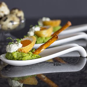 Laugen-Crostini mit Erbsen-Püree und frittiertem Wachtelei