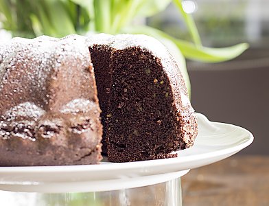 Angeschnittener Schokoladen-Gugelhupf mit gehackten Pistazien